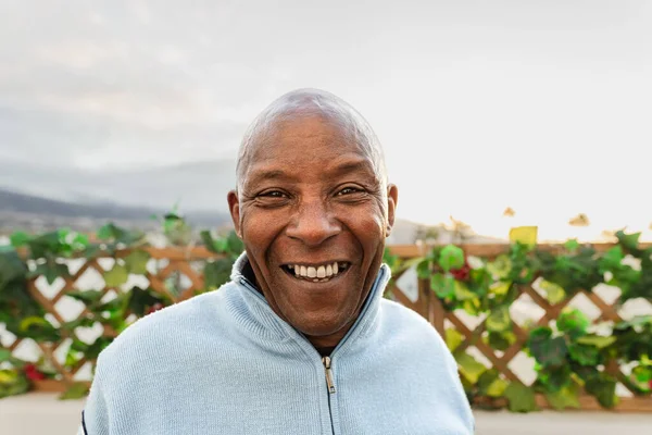 Счастливый Пожилой Африканский Мужчина Улыбается Перед Камерой Патио — стоковое фото