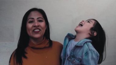Happy filipina mother with her daughter throwing confetti together outdoor - Family love concept