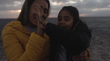 Happy Latin mother enjoying time with her child on the beach - Family and love concept