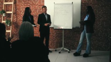 Konferans odasında çalışan çok ırklı iş adamları çeşitli yaratıcı girişimcilerden oluşan bir ekip iş görüşmesi yapıyor. 