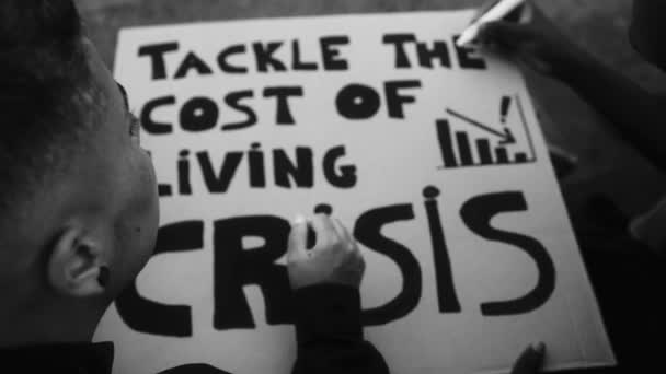 金融危機と世界的なインフレに対する抗議バナーを準備活動家 白黒編集 — ストック動画