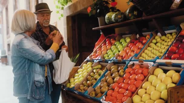Ευτυχισμένο Ηλικιωμένο Ζευγάρι Που Αγοράζει Φρέσκα Φρούτα Στην Αγορά Shopping — Αρχείο Βίντεο