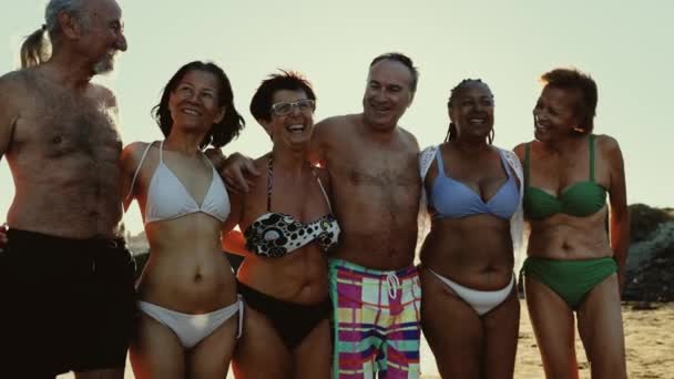 Gelukkige Multiraciale Senioren Die Plezier Beleven Aan Strandwandelingen Bij Zonsondergang — Stockvideo