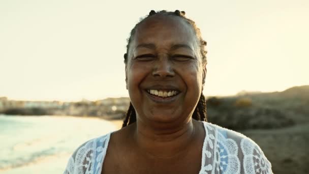 暑假期间 快乐的非洲老年女性在海滩上对着摄像机笑得开心 老年人生活方式的概念 — 图库视频影像