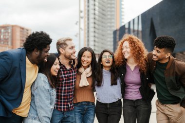 Young multi ethnic friends having fun together hanging out in the city - Friendship and diversity concept