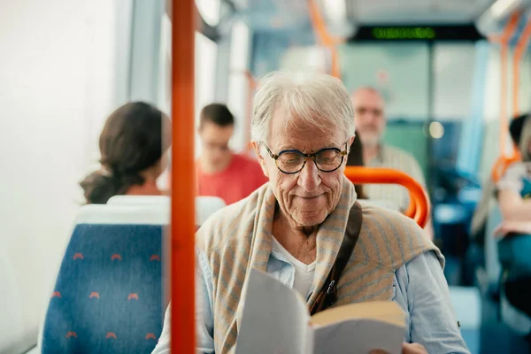 Pria Senior Membaca Buku Saat Bepergian Dengan Bus — Stok Foto