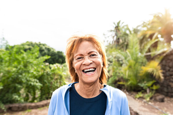 Happy Senior Latin Woman Smiling Camera While Walking Public Park Stock Photo