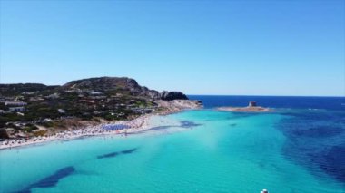 Akdeniz 'in en güzel deniz kenarlarından biri olan La Pelosa plajının manzaralı manzarası, İtalya' nın kuzeyindeki Stintino kasabasında yer almaktadır.
