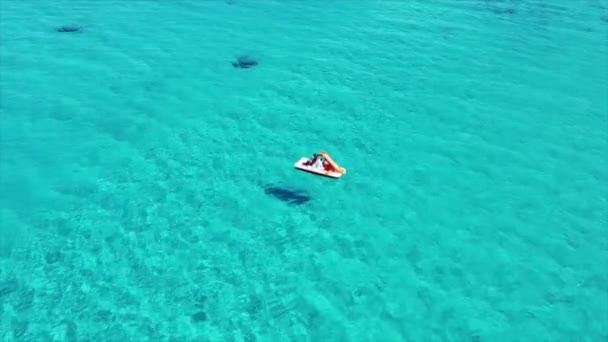 意大利撒丁岛Stintino市La Pelosa海滩上一只脚踏船漂浮在美丽的绿松石海上的空中照片 — 图库视频影像