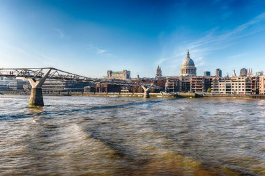 Thames nehri üzerinde manzaralı panoramik manzara ve Millennium Köprüsü ile ufuk çizgisi ve Londra, İngiltere ve İngiltere 'nin önemli simgelerinden bazıları.