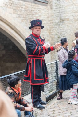 13 Nisan 2022: İngiltere 'nin tarihi Londra Kulesi turu sırasında bir Yeomen Bekçisi ziyaretçilere sesleniyor. Halk arasında Beefeater olarak bilinir. Londra Kulesi 'nin törensel koruyucularıdır.