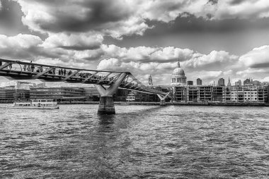 Thames nehri üzerinde manzaralı panoramik manzara ve Millennium Köprüsü ile ufuk çizgisi ve Londra, İngiltere ve İngiltere 'nin önemli simgelerinden bazıları.