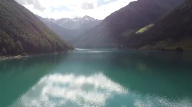 Turkuaz su, İtalya 'nın Trentino Alto Adige kentindeki Vernago Gölü' nde güneşli bir yaz gününün mavi gökyüzünü yansıtıyor.