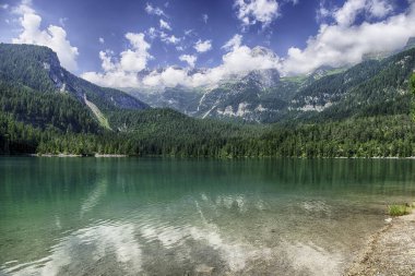 Güneşli bir yaz gününde arka planda Brenta Dolomitleri olan güzel Tovel gölünün panoramik manzarası, Trentino Alto Adige, İtalya