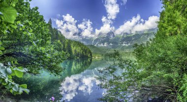 Güneşli bir yaz gününde arka planda Brenta Dolomitleri olan güzel Tovel gölünün panoramik manzarası, Trentino Alto Adige, İtalya