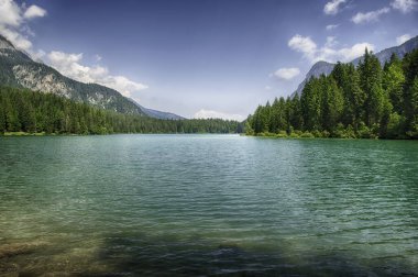 Güneşli bir yaz gününde arka planda Brenta Dolomitleri olan güzel Tovel gölünün panoramik manzarası, Trentino Alto Adige, İtalya