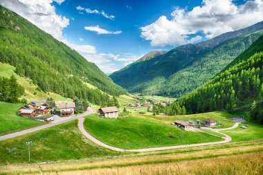 İtalya Alplerinde yuva yapmış, Schnalstal, Trentino Alto Adige, İtalya 'daki yemyeşil dağlarla çevrili küçük bir köyün nefes kesici manzarası.