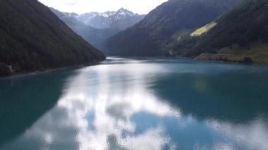 Turkuaz su, İtalya 'nın Trentino Alto Adige kentindeki Vernago Gölü' nde güneşli bir yaz gününün mavi gökyüzünü yansıtıyor.