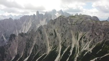 İtalya 'nın İtalyan Dolomitleri' ndeki Cadini di Misurina dağ sırasının yüksek ve kayalık tepelerine uzanan bir dağ çayırında çakıl yürüyüşü patikası dönüyor.