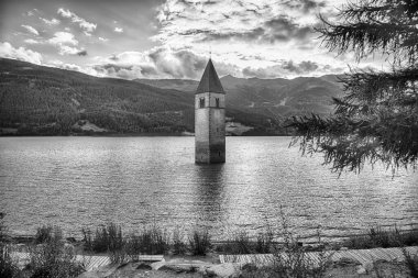 Güney Tyrol, Curon Venosta 'daki Reschensee yapay gölünün suyundan çıkan ikonik eski Graun kilise kulesi.