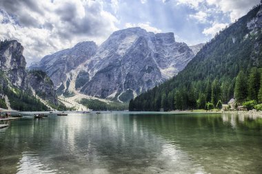 Braies Gölü 'nün ikonik manzarası turkuaz sularıyla Dolomitler, Güney Tyrol, İtalya' da dağlar ve ormanlarla çevrili.