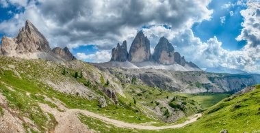 Kuzeydoğu İtalya 'nın Sexten Dolomitleri' ndeki Paternkofel ve Tre Cime di Lavaredo tepelerine uzanan yeşil bir vadinin manzarası.