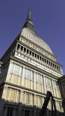 İtalya 'nın Torino kentinin en ikonik simgesi olan Köstebek Antonelliana canlı mavi gökyüzüne karşı yükselir ve karmaşık mimarisini ve kulesini gözler önüne serer.