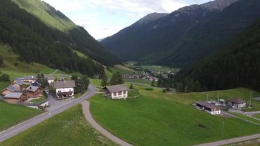 İtalya Alplerinde yuva yapmış, Schnalstal, Trentino Alto Adige, İtalya 'daki yemyeşil dağlarla çevrili küçük bir köyün nefes kesici manzarası.