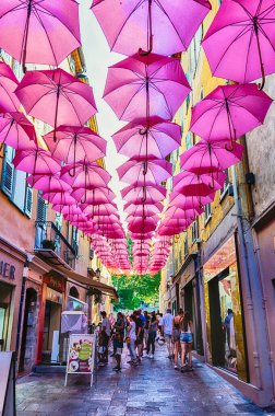 Grasse, Fransa 'nın tarihi merkezi Cote d' Azur 'daki şehir sokaklarını süsleyen ikonik pembe şemsiyeler, 17 Ağustos 2019
