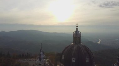 Hava perspektifinde İtalya 'nın Torino kentinde sonbahar yeşillikleri arasında yuva yapmış Superga Bazilikası sergileniyor.