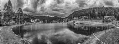 Madonna di Campiglio 'nun şehir gölü yazın yağmurlu bir günde bulutlu gökyüzünü yansıtan Trentino Alto Adige, İtalya