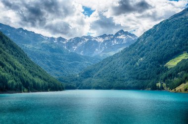 Turkuaz su, İtalya 'nın Trentino Alto Adige kentindeki Vernago Gölü' nde güneşli bir yaz gününün mavi gökyüzünü yansıtıyor.