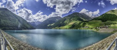 Turkuaz su, İtalya 'nın Trentino Alto Adige kentindeki Vernago Gölü' nde güneşli bir yaz gününün mavi gökyüzünü yansıtıyor.