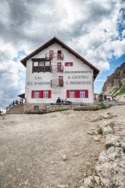 SESTO, İtalya - 26 Temmuz 2024: İtalyan Alpleri, Güney Tyrol, İtalya 'daki bir yürüyüş gününden sonra Rifugio Locatelli dağ kulübesinde mola veren turistler