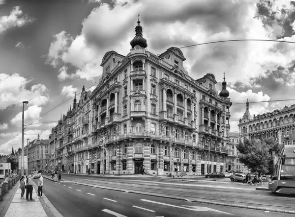 PRAG - 12 Mayıs 2024: Prag, Çek Cumhuriyeti 'nde güneşli bir günün tadını çıkaran turistler, işlek bir caddede tarihi binalar ve tramvayla yürüyor