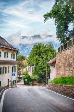 Asfalt yol bir tepenin yukarısında Collalbo, Renon Platosu, İtalya 'daki İtalyan Dolomitlerine doğru kıvrılıyor.