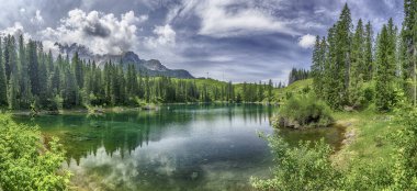 Zümrüt yeşili Carezza Gölü 'nün panoramik manzarası İtalyan Dolomitleri' ndeki Latemar Dağı 'nı yansıtıyor, Trentino Alto Adige, İtalya