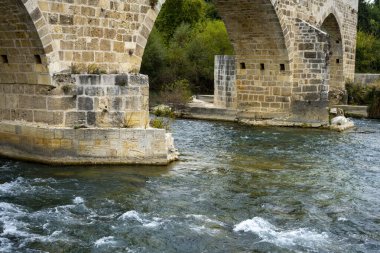 Aspendos 'taki Seljuk Köprüsü. Eurymedon Köprüsü. Aspendos Yolu Belkis Mevkii. Hindi. Çarpık köprü. Güney Anadolu, Pamphylia 'da Aspendos yakınlarındaki Koprucay (Euremedon) Nehri üzerindeki köprü 
