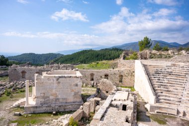Bir Opramoas anıtı, su kemeri, küçük bir tiyatro, bir Asclepius tapınağı, lahit ve antik Lycia 'da bir şehir olan Rhodiapolis' ten gelen kiliselerin kalıntıları. Bugün Kumluca 'da yer almaktadır.