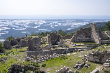 Bir Opramoas anıtı, su kemeri, küçük bir tiyatro, bir Asclepius tapınağı, lahit ve antik Lycia 'da bir şehir olan Rhodiapolis' ten gelen kiliselerin kalıntıları. Bugün Kumluca 'da yer almaktadır.