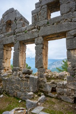 Remains of gymnasium in acnient Lycian city Arycanda. Ancient city on mountain near Aykiricay village.Well preserved semi-circular theater of Arycanda, ancient Lycian city in Antalya, Turkey. clipart