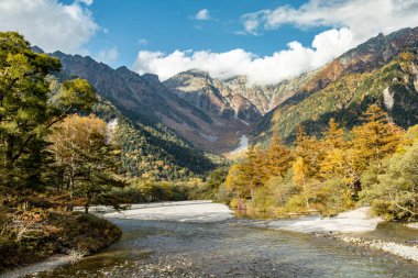 Kamikochi Milli Parkı 'nın arka planında kar dağları, kayalar ve yaprakların renk değiştirdiği tepelerden Azusa nehirleri mevsimi vardı..