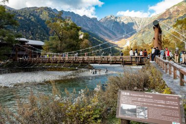 Kamikochi, Nagano, Japonya - Ekim 2022: Kimliği belirsiz turistler, Sonbahar Yeşillik sezonu boyunca Kamikochi Ulusal Parkı 'nın merkez alanındaki Kappa bashi Köprüsü' nde keyif çattı. 