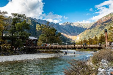 Kamikochi, Nagano, Japonya - Ekim 2022: Kimliği belirsiz turistler, Sonbahar Yeşillik sezonu boyunca Kamikochi Ulusal Parkı 'nın merkez alanındaki Kappa bashi Köprüsü' nde keyif çattı. 