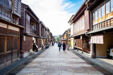Kanazawa, Japonya - Ekim 2022: Japonya 'nın Kanazawa kentindeki Higashi Chaya Gai' de turistler cadde boyunca yürüyorlar. Bazı turist eşyaları kimonoları ve geyşalar etrafta dolanıyor..