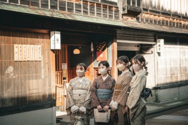 Kanazawa, Japonya - Ekim 2022: Tanımlanamayan turist eşyaları kimonoları ve bazı geyşalar etrafta dolaşıyor. Japonya 'nın Kanazawa bölgesindeki Higashi Chaya Gai' de turistler yürüyor.. 