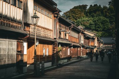 Kanazawa, Japonya - Ekim 2022: Tanımlanamayan turist eşyaları kimonoları ve bazı geyşalar etrafta dolaşıyor. Japonya 'nın Kanazawa bölgesindeki Higashi Chaya Gai' de turistler yürüyor.. 