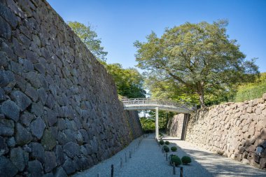 Kanazawa, Japonya: Ekim 2022 - Kanazawa, Ishikawa, Japonya 'da taş şatosu ve mavi gökyüzü ile Kanazawa Kalesi Parkı. Beyaz renkli ve taştan duvarları olan ünlü tarihi bir yer..