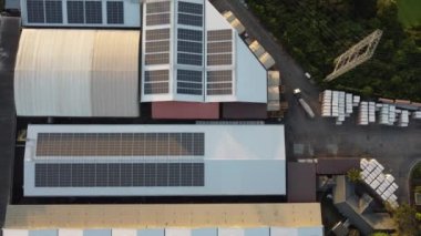 Fly over Solar cells farm beside nature green farm around large industrial factory area. Solar farms are generating renewable energy for the industry. 