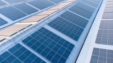 Geleceğin yeşil enerjisi ve sürdürülebilir elektrik kaynağı kavramı. Açık havada güneş panelleri çatılarda ya da İHA 'larla fabrikaların fotovoltaikleri üzerinde yoğunlaşıyor. Mavi tonlu güneş pili ızgaralı endüstriyel çatı.